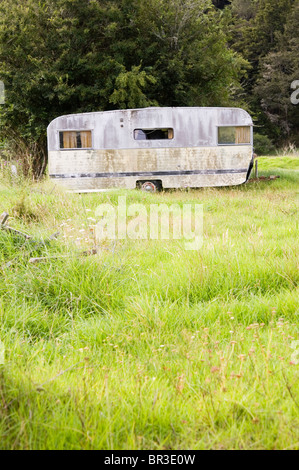 Eine alte, heruntergekommene Wohnwagen hat auf einer Wiese für den Rest seiner Tage abgestellt. Irgendwo auf der Nordinsel Neuseelands. Stockfoto