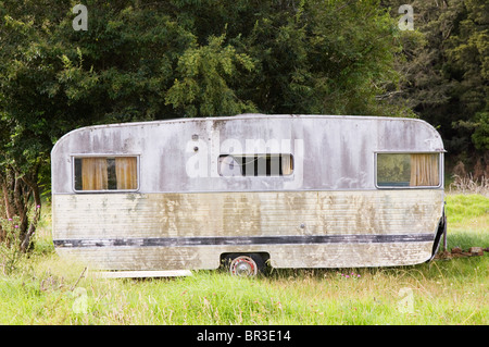 Eine alte, heruntergekommene Wohnwagen hat auf einer Wiese für den Rest seiner Tage abgestellt. Irgendwo auf der Nordinsel Neuseelands. Stockfoto