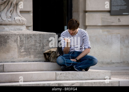 junger Mann in ein Iphone mit Kopfhörer in den Straßen sprechen Stockfoto