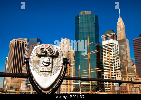 Pay-Fernglas mit Blick auf alte Segelschiffe mit den Gebäuden des Lower Manhattan über New York City, USA Stockfoto