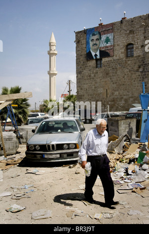 Eine schmutzige Straße mit einem ein Porträt des verstorbenen libanesischen Premierministers Rafic Hariri im Hintergrund in Sidon im Libanon zu sehen. Stockfoto