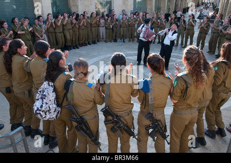 eine Gruppe von weiblichen Soldaten tanzen zu den Klängen von zwei Klezmer-Musiker im Rahmen ihres Besuchs in Jerusalem Stockfoto