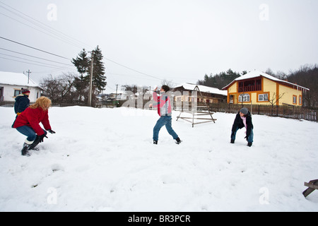 Junge Familie Spaß mit einer Schneeballschlacht in Winterurlaub Stockfoto