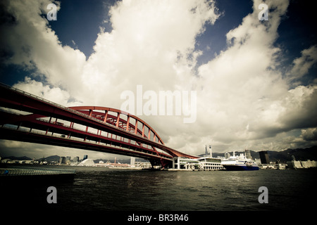 Ein Kreuzfahrtschiff im Hafen von Kobe mit der Brücke an Port Island sichtbar in den Vordergrund, Kobe, Japan (getönten Bild) angedockt. Stockfoto