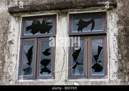 Zerbrochene Fensterscheiben in einem verlassenen Haus. Stockfoto