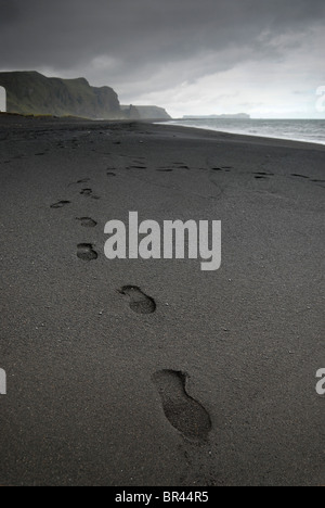 Fußabdrücke im Lavastrand in Vik, Island. Stockfoto