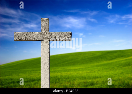 Religiöse Steinkreuz auf einem schönen grünen Hügel Stockfoto