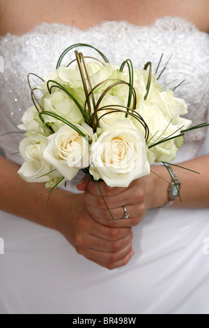 Eine Braut hält einen Strauß weißer Blumen am Tag ihrer Hochzeit Stockfoto