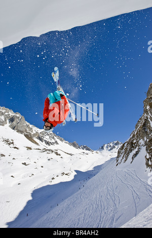 Ein Mann führt ein Back Flip aus einem Gesims beim Skifahren abseits der Pisten in der Nähe von St. Anton am Arleberg, Österreich. Stockfoto