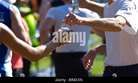 Kleine Kunststoff-Flaschen von Buxton immer noch Mineralwasser Konkurrenten in Nottingham Marathon übergeben wird Stockfoto