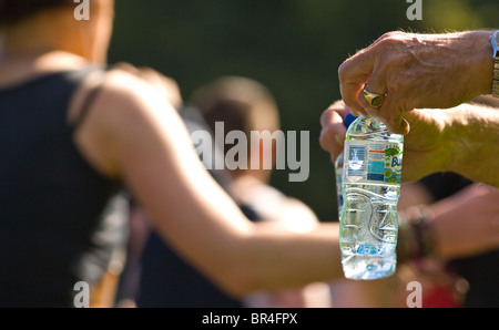 Kleine Kunststoff-Flaschen von Buxton immer noch Mineralwasser Konkurrenten in Nottingham Marathon übergeben wird Stockfoto