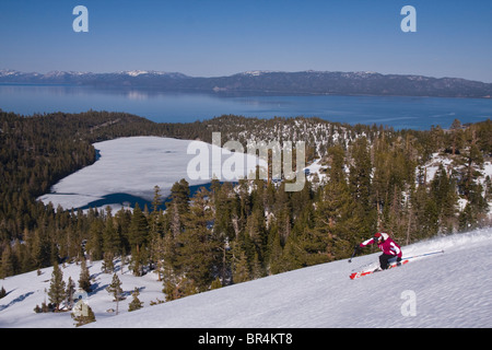 Eine Frau an einem Tag blauer Himmel über dem Lake Tahoe und gefrorenen Wasserfall See Skifahren. Stockfoto