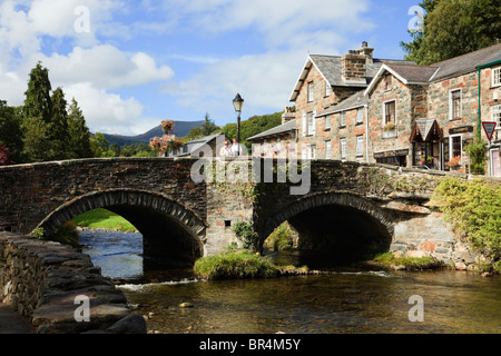 Blick entlang Afon Colwyn Fluss zu alten Bogenbrücke der Snowdonia Dorfzentrum. Beddgelert, Gwynedd, Wales, Großbritannien, Großbritannien. Stockfoto