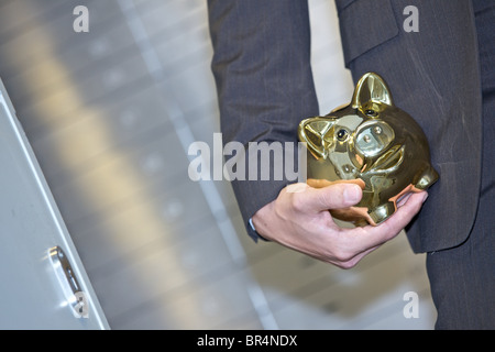 Mann vor Safes halten goldene Sparschwein, close-up Stockfoto