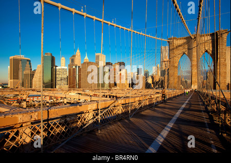 Am frühen Morgen auf der Brooklyn Bridge mit den Gebäuden des Lower Manhattan über New York City, USA Stockfoto