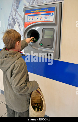 8 jähriger Junge mit Pfand Flaschen an einer Rückkehr Maschine, Deutschland, Europa Stockfoto