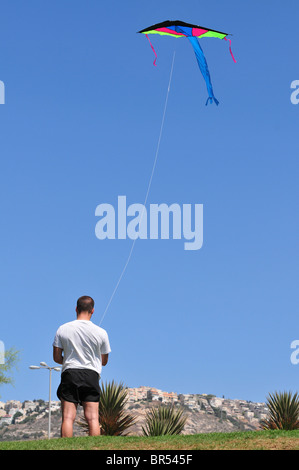 Israel, Haifa, Carmel Beach, Israelis gehen an den Strand an einem warmen, sonnigen Tag Mann einen Drachen fliegt Stockfoto