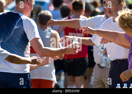 Kleine Kunststoff-Flaschen von Buxton immer noch Mineralwasser Konkurrenten in Nottingham Marathon übergeben wird Stockfoto