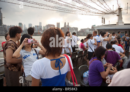 Touristen auf einem Boot Kreuzfahrt auf dem Huangpu-Fluss in Shanghai China. Stockfoto