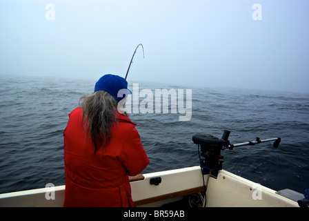 Frau Angler spielen Lachs offshore in nebligen öffnen Pazifischen Ozean in der Nähe von Ucluelet Stockfoto