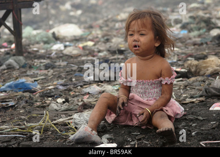 Ein junges Mädchen zeigt die ungesunden Auswirkungen des Lebens in einer Müllkippe bei Stung Meanchey Mülldeponie in Phnom Penh, Kambodscha. Stockfoto