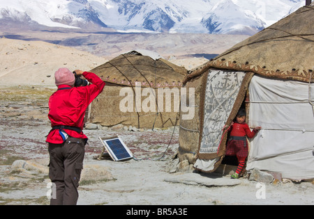 Westliche Touristen fotografieren kirgisischen Menschen Jurten Karakuli See, Mt. Kunlun in der Ferne, Pamir Plateau, Xinjiang, Kinn Stockfoto