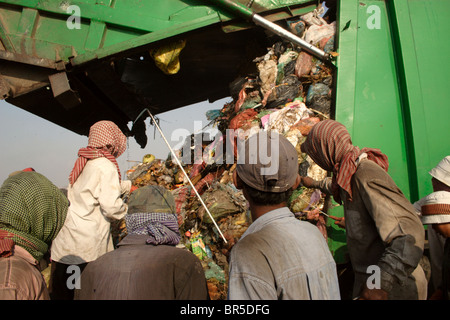 Arbeitnehmer, die Wertstoffe sammeln grüßen ein weiteres Müllwagen am Stung Meanchey Deponie in Phnom Penh, Kambodscha. Stockfoto