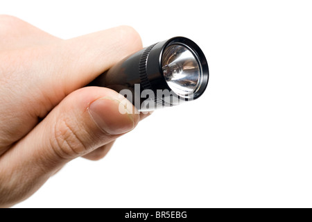 Schwarze Taschenlampe in einer Hand, isoliert auf weiss. Stockfoto