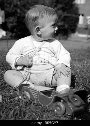 Historisches Foto, kleiner Junge spielt mit einem hölzernen Auto ca. 1924 Stockfoto