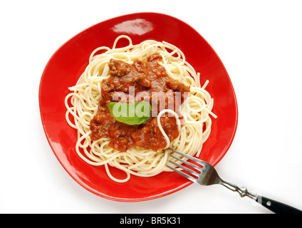 Spaghetti mit Tomatensauce auf rotem Teller mit Gabel, isoliert auf weißem Hintergrund Stockfoto