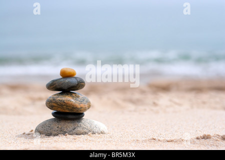 Ein Steinhaufen Runde glatte Zen gestapelt in den Sand am Strand. Stockfoto