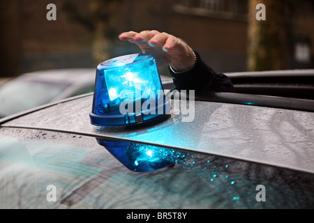 Ein Polizist stellt das Blaulicht auf Dach eine Undercover Polizei Autos. Stockfoto