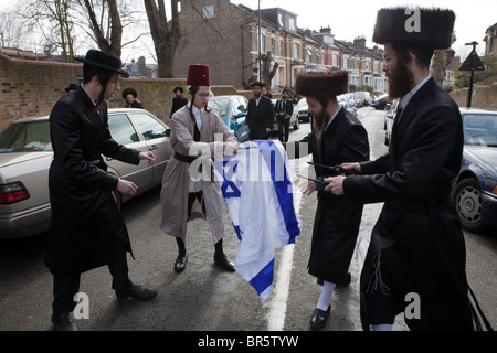 Mitglieder der Ultra-Orthodoxen jüdischen Anti-Zionist Gruppe, Neturei Karta, brennen die israelische Flagge. Stamford Hill. Stockfoto