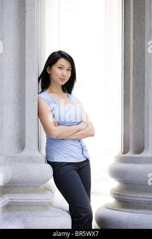 Chinesische Geschäftsfrau gelehnt Steinsäule Stockfoto