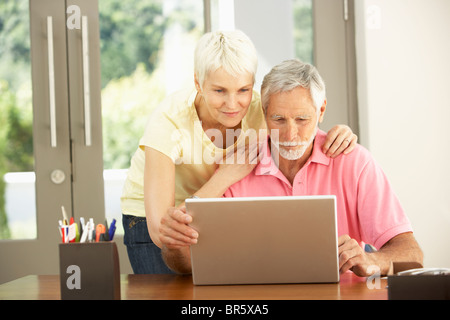Älteres Paar mit Laptop zu Hause Stockfoto