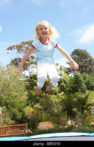 Junges Mädchen springen auf dem Trampolin im Garten Stockfoto