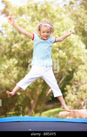 Junges Mädchen springen auf dem Trampolin im Garten Stockfoto