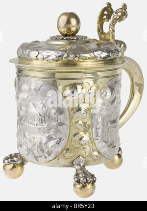 Ein silberner Tankard mit Deckel, Nürnberg, ca. 1660/70 Silber, teilweise vergoldet. Zylindrischer Körper an drei Klauen- und Kugelfüßen. Drei umliegende Kartuschen mit Darstellungen von Landschaften zwischen Akanthusblättern. Klappdeckel mit gehämmerten Darstellungen von Landschaften, der obere Knopf in Form einer Frucht auf einem durchbohrten Zierteller. Durchbohrter Daumenhebel in Form von Tendrillen. Deckel und Boden mit Meistermark Mühle (Mühle), Kennzeichen Nürnberg und Zickzackmarke des Assayers. Höhe 18,7 cm, Gewicht 685 g. Die Mühlenzeichenkennzeichnung wurde von mehreren Mitgliedern der Familie Müller in nur, Stockfoto