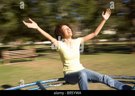 Junge Frau Reiten am Kreisverkehr im Park Stockfoto