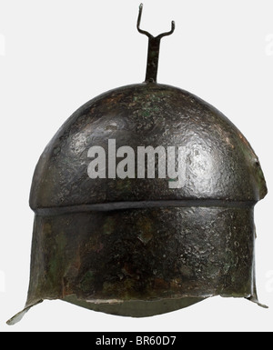 Ein apulianisch-korinthischer Helm aus Bronze, 5. Jahrhundert vor Christus, hoher Helm mit versetzter Kalotte und deutlich konturierten Augenbrauen. Kleine Augenausschnitte mit nach unten ragenden Randgravuren, die auf den Nasenschutz und die Trennlinie für die Wangenstücke hinweisen. Gravierte Darstellungen von Wildschweinen auf den Wangenstücken. Eine an der Krone genietete Pflaumgabel. Zwei Löcher für die Kinnbeine an den Seiten des unteren Randes. Höhe 22,5 cm. Gewicht 630 g Grünlich-braune Patina. Nur Reste des Halsschützers sind erhalten. Die rechte Seite ist leicht eingedrückt und gebrochen. Stockfoto