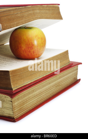 Roter Apfel dazwischen Seiten der alten Buch auf weißem Hintergrund Stockfoto