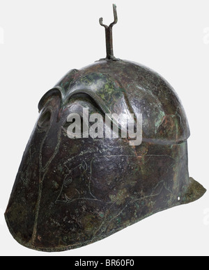 Ein apulianisch-korinthischer Helm aus Bronze, 5. Jahrhundert vor Christus, hoher Helm mit versetzter Kalotte und deutlich konturierten Augenbrauen. Kleine Augenausschnitte mit nach unten ragenden Randgravuren, die auf den Nasenschutz und die Trennlinie für die Wangenstücke hinweisen. Gravierte Darstellungen von Wildschweinen auf den Wangenstücken. Eine an der Krone genietete Pflaumgabel. Zwei Löcher für die Kinnbeine an den Seiten des unteren Randes. Höhe 22,5 cm. Gewicht 630 g Grünlich-braune Patina. Nur Reste des Halsschützers sind erhalten. Die rechte Seite ist leicht eingedrückt und gebrochen. Stockfoto