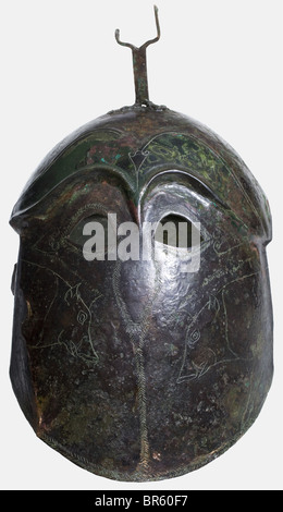 Ein apulianisch-korinthischer Helm aus Bronze, 5. Jahrhundert vor Christus, hoher Helm mit versetzter Kalotte und deutlich konturierten Augenbrauen. Kleine Augenausschnitte mit nach unten ragenden Randgravuren, die auf den Nasenschutz und die Trennlinie für die Wangenstücke hinweisen. Gravierte Darstellungen von Wildschweinen auf den Wangenstücken. Eine an der Krone genietete Pflaumgabel. Zwei Löcher für die Kinnbeine an den Seiten des unteren Randes. Höhe 22,5 cm. Gewicht 630 g Grünlich-braune Patina. Nur Reste des Halsschützers sind erhalten. Die rechte Seite ist leicht eingedrückt und gebrochen. Stockfoto