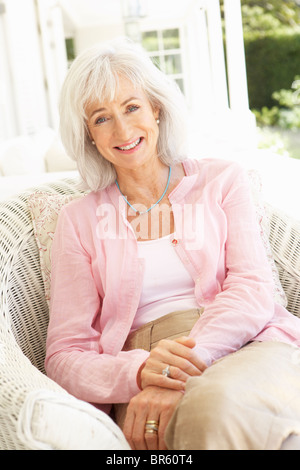 Portrait Of Senior Woman entspannend im Stuhl Stockfoto