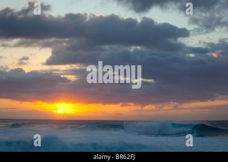 Kauai, Hawaii: Untergehende Sonne bricht durch die Wolken vor der Na Pali Küste in der Nähe von Ke'e Strand Stockfoto