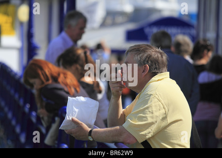 Ein Mann genießt einige Fish And Chips am Pier von Eastbourne, East Sussex, England. Stockfoto