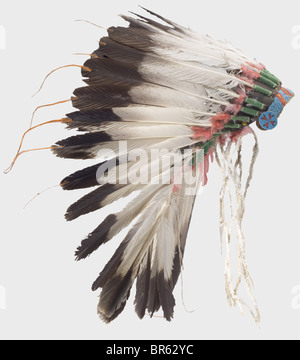 A Plains Indian war Bonnet, USA, Anfang des 20. Jahrhunderts. Eine Krone aus großen Adlerfedern, die untere mit rot gefärbten Daunenfedern verziert ist, die an einer Filzkappe befestigt sind. Die Stirnpartie ist mit farbigen Perlen bestickt. Höhe ca. 45 cm. Eine Kriegshaube wurde nur zu besonderen Anlässen getragen, die reichen Dekorationen berichteten von den siegreichen Kämpfen seines Besitzers. Allein die Adlerfedern waren sehr kostbar und hatten noch mehr Wert als gutes Pferd: Historisches, historisches Amerikanerchen, Amerika, Völkerkunde, Ethnie, Ethnie, Objekt, Objekte, Schnitten, Ausschneiden, Ausschneiden, Ausschneiden, Ware, Stockfoto