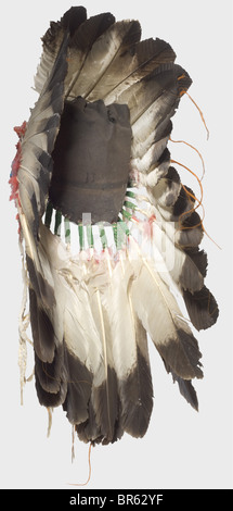 A Plains Indian war Bonnet, USA, Anfang des 20. Jahrhunderts. Eine Krone aus großen Adlerfedern, die untere mit rot gefärbten Daunenfedern verziert ist, die an einer Filzkappe befestigt sind. Die Stirnpartie ist mit farbigen Perlen bestickt. Höhe ca. 45 cm. Eine Kriegshaube wurde nur zu besonderen Anlässen getragen, die reichen Dekorationen berichteten von den siegreichen Kämpfen seines Besitzers. Allein die Adlerfedern waren sehr kostbar und hatten noch mehr Wert als gutes Pferd: Historisches, historisches Amerikanerchen, Amerika, Völkerkunde, Ethnie, Ethnie, Objekt, Objekte, Schnitten, Ausschneiden, Ausschneiden, Ausschneiden, Ware, Stockfoto