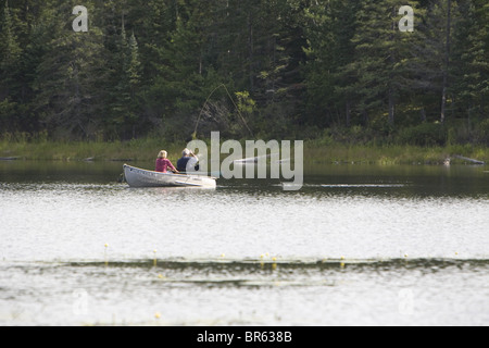 Ein paar Fliege fischt und fängt einen Fisch von einem Boot auf einem See in Wisconsin. Stockfoto