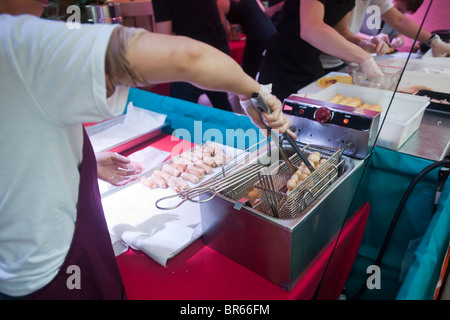 Köche beeilen, um zu halten mit der Nachfrage nach Frühlingsrollen auf dem malaysischen Nachtmarkt im Meatpacking District in New York Stockfoto